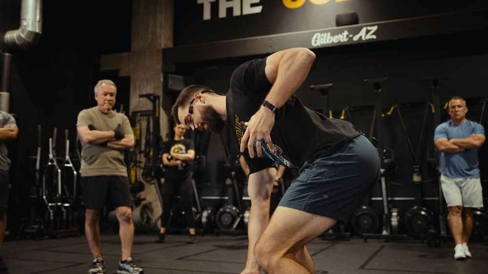 A coach demonstrating a movement to a group at The Collective in Gilbert.